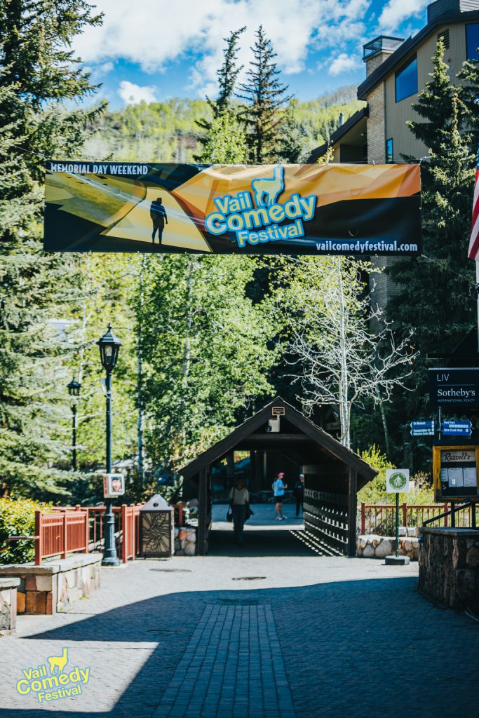 The iconic covered bridge in Vail, Colorado under a Vail Comedy Festival banner at the 2022 Vail Comedy Festival