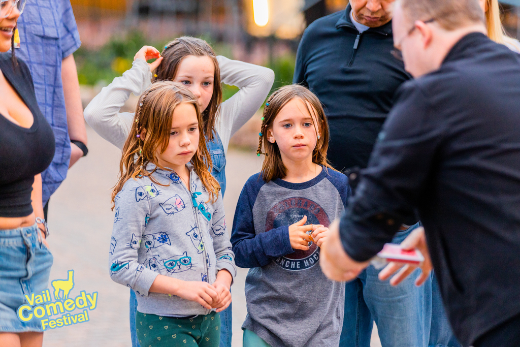 Ambient entertainment was a permitted activity during the 2022 Vail Comedy Festival.  Pictured are future comedy fans enjoying card tricks from a professional magician.