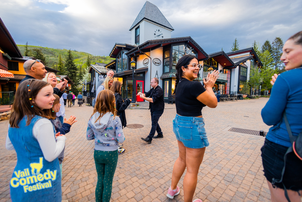 In the heart of Vail Village during the 2022 Vail Comedy Festival a magician amazes passers-by as audience members cheer